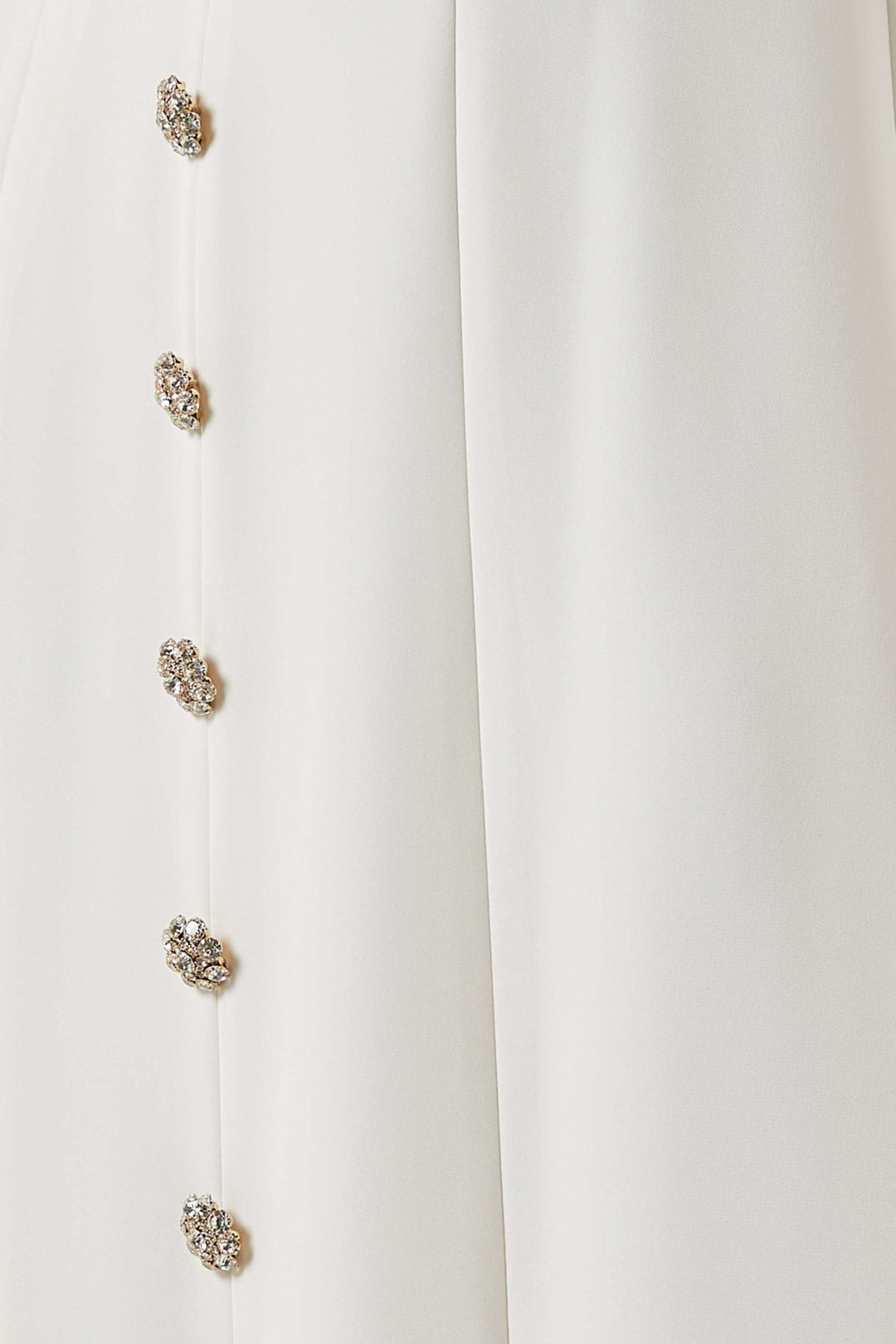 فستان بفتحة رقبة منسدلة وأزرار مرصعة بالجواهر – عاجي