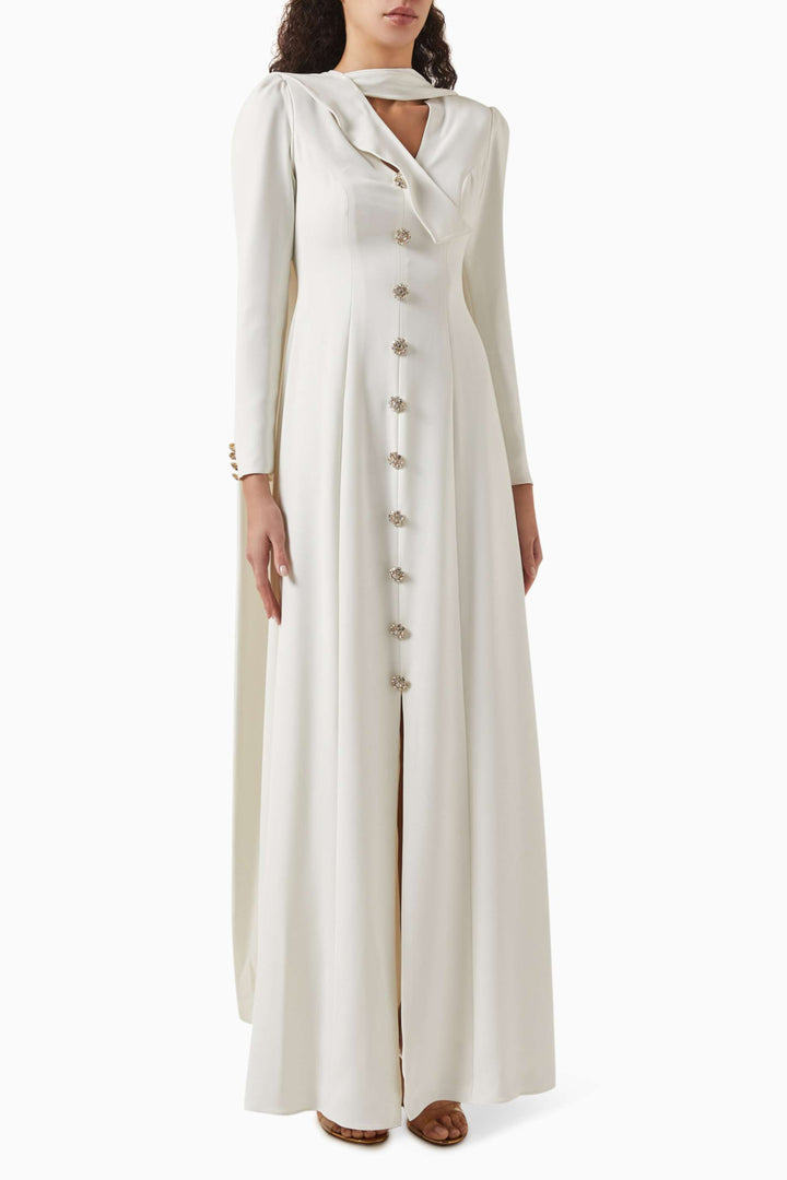 فستان بفتحة رقبة منسدلة وأزرار مرصعة بالجواهر – عاجي